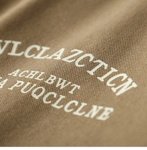 Macro detail of brown twill knit fabric showing white letter printing and fine texture