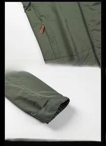 Detail view of military green outdoor jacket featuring zippered pockets and adjustable cuffs
