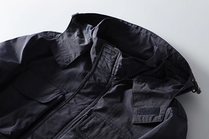 Detailed view of deep blue outdoor jacket with windproof collar and cargo pockets