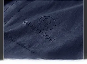 Detailed macro view of the embossed OUTDOOR logo on navy blue quick-dry fleece fabric