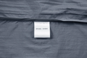 Close-up of the wash label on a summer sun protection jacket showing 100% nylon material