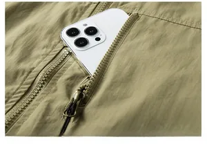 Détail de la poche de poitrine zippée sur gilet de plein air avec un smartphone