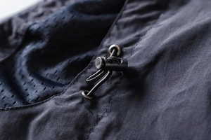 Detail of adjustable drawstring toggle and breathable mesh lining on outdoor jacket