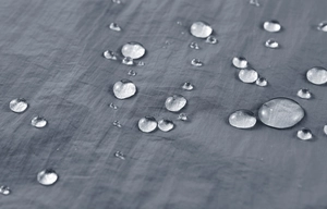 Macro detail of grey ripstop fabric showing water-resistant lotus effect droplets
