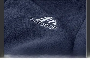 Detail of outdoor embroidery and soft polar fleece texture on blue winter vest
