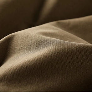 Detail of heavy brown canvas fabric showing tight weave texture on workwear jacket