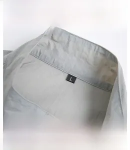 Close-up of lightweight grey sun protection jacket fabric with hood detail and size L label