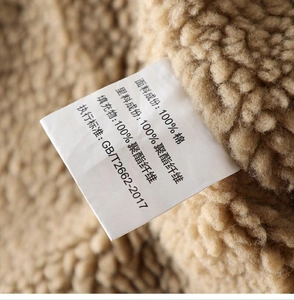 Detail view of cotton care label on warm brown sherpa fleece lining for jacket