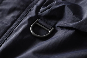 Detail of dark blue waterproof fabric with a durable matte grey metal D-ring buckle