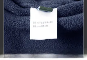 Macro shot of product care label on navy fleece vest showing material composition details