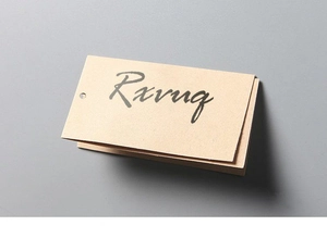 Detailed macro view of a vintage kraft paper garment tag with an engraved brand logo