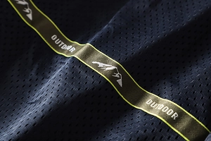 Close-up of breathable navy mesh fabric with outdoor logo embroidery on green ribbon