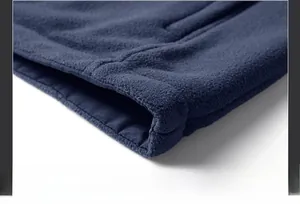 Detail of double-stitch sewing on the hem of a navy blue thick polar fleece vest
