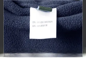 Detail of white wash care label showing fabric composition on navy fleece vest