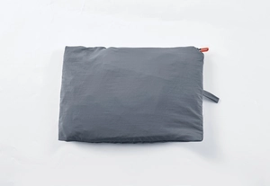 Detail of lightweight gray sun protection jacket folded into a compact storage pouch