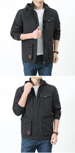 Detail of men's black hooded outdoor jacket with multiple utility pockets and zip arm pocket