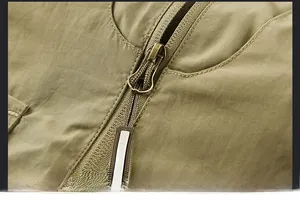 Close-up of olive green outdoor vest with durable metal zipper and nylon puller detail