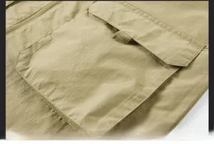 Close-up of khaki multi-pocket vest showing durable stitching and flap pocket details