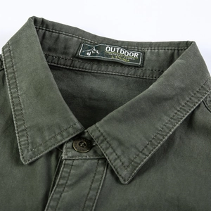 Gros plan du col de chemise en coton vert armée avec boutons en métal et étiquette