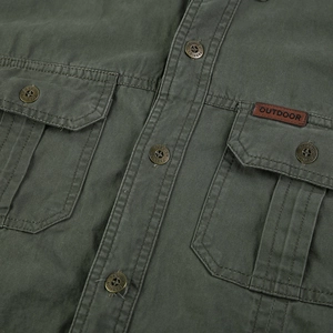 Gros plan de chemise militaire en coton vert avec poches poitrine et étiquette outdoor
