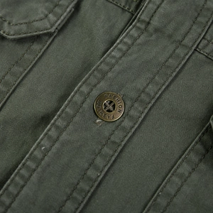 Détails macro des boutons en métal et des coutures sur la chemise en coton vert