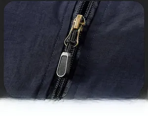 Close-up of durable golden metal zipper on navy blue ripstop outdoor vest