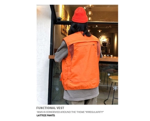Detail of orange tactical vest featuring breathable black mesh back and large zipper pocket