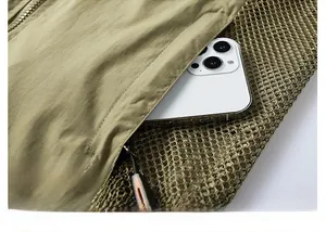 Detail of olive outdoor vest featuring zip pocket and breathable mesh lining