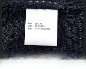 Detail view of black mesh fabric with white care label showing material composition