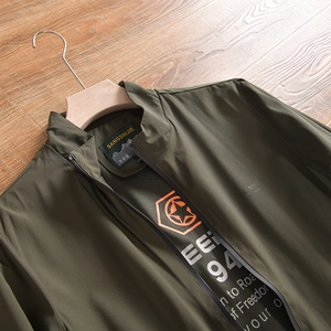 Détail du col d'une veste d'extérieur vert olive avec fermeture éclair et étiquette de marque