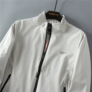 Dettaglio della giacca grigio chiaro con collo alto, zip e logo Fashion Milano