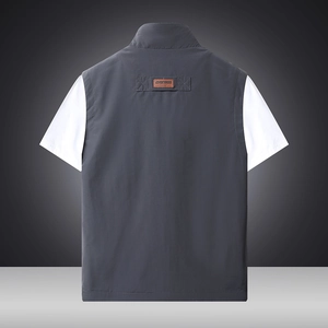 Back view of a dark grey outdoor photography vest featuring an embossed leather back label