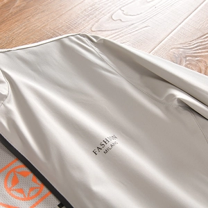 Détail de la veste séchage rapide gris clair avec texte Fashion Milano et fermeture