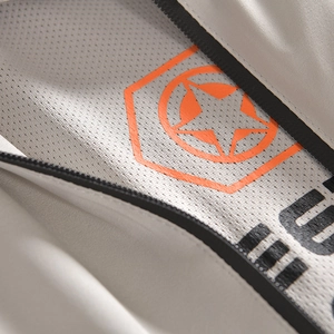 Vue macro de la doublure en maille respirante et logo orange sur veste grise