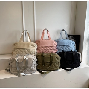 Close-up of quilted nylon travel bags in various colors for fitness and travel