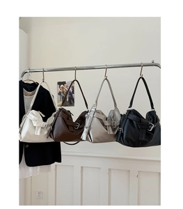 Detail view of four minimalist faux leather hobo bags in white, brown, silver and black