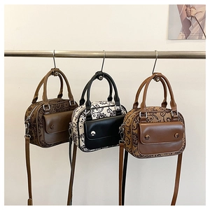 Detailed display of three vintage paisley crossbody bags in different brown and black tones