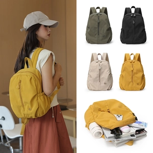 Detail view of large capacity nylon backpack in yellow, olive, black and off-white colors