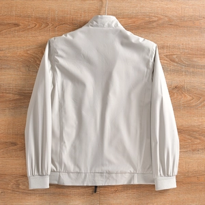 Détail de la veste d'extérieur gris clair avec poignets côtelés et col montant