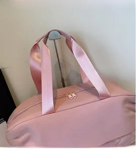 Detail view of pink large capacity travel bag with nylon strap and dual zipper closure