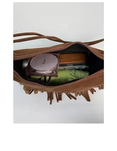 Sac à bandoulière en daim marron avec franges montrant l'espace de rangement intérieur