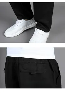 Detail view of black cotton casual trousers showing the hem design and rear flap pocket