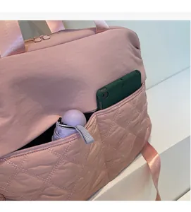 Pink quilted travel bag detail showing side pocket storage for tablet and umbrella