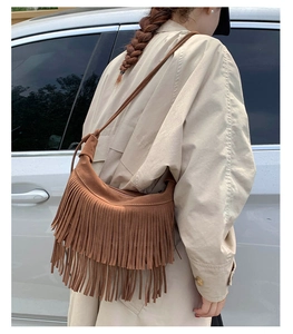 Vue détaillée d'un sac bandoulière en daim marron avec longues franges bohèmes et sangle