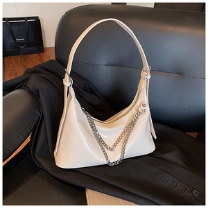 Detail of cream crescent shoulder bag featuring double silver metal chains and smooth leather