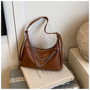 Detail of brown faux leather hobo bag with silver chains and adjustable shoulder strap