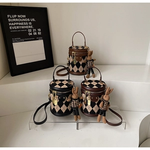 Detailed view of vintage quilted bucket bags in three colors with rabbit doll pendants