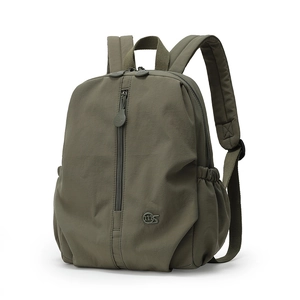 Macro view of olive green nylon backpack featuring a vertical zipper pocket and logo