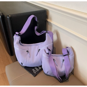 Comparison of large and small light purple nylon dumpling bags in a lifestyle setting