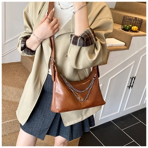 Shoulder bag in caramel finish with double silver metal chain details worn by model